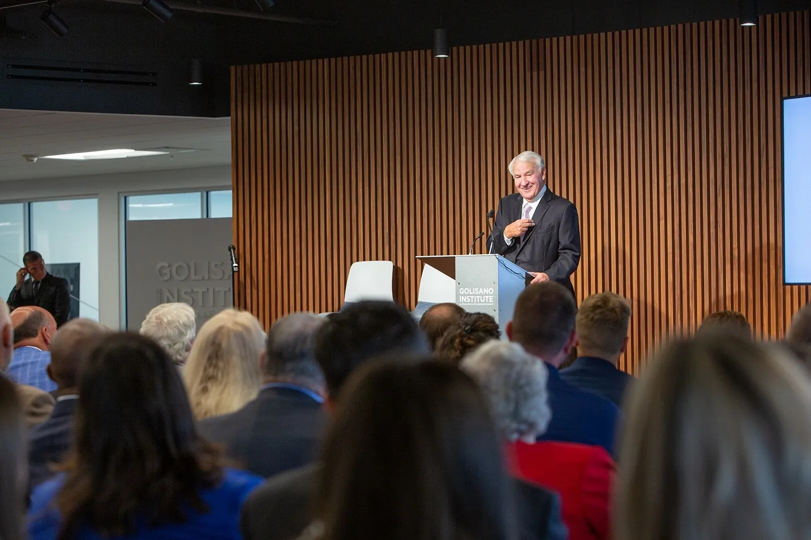 Tom Golisano speaking in front of a room full of people and reporters, discussing his philanthropic giving and major awards to 82 local non-profit organizations.